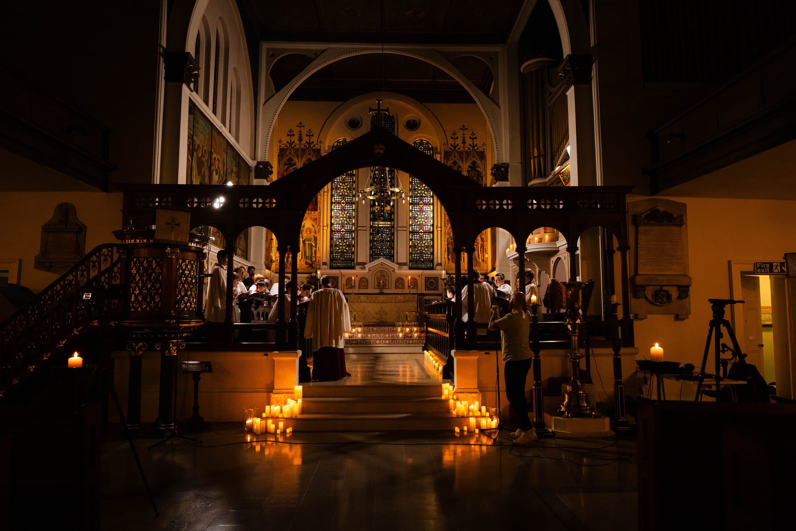 Candles light the way through St George’s to the choir and stained-glass east window