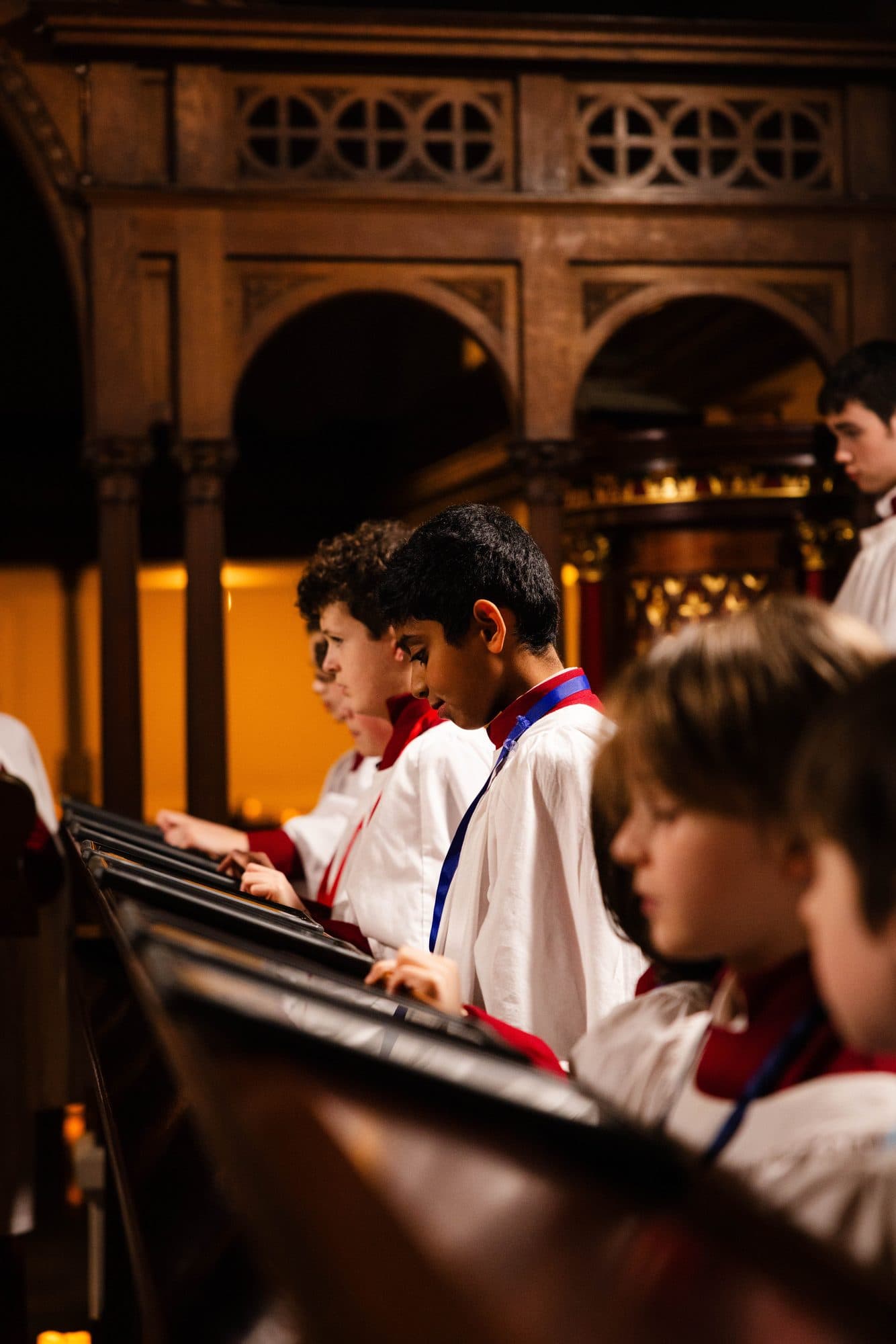 Young choristers of St George's following the music in the choir stalls